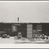 Three-room shack, the residence of L.H. Nissen, hired man for a tenant farmer. Farm is owned by a loan company. Ten people live in the shack: mother, father, seven children, and one grandchild. Iowa