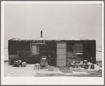 Three-room shack, the residence of L.H. Nissen, hired man for a tenant farmer. Farm is owned by a loan company. Ten people live in the shack: mother, father, seven children, and one grandchild. Iowa