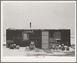 Three-room shack, the residence of L.H. Nissen, hired man for a tenant farmer. Farm is owned by a loan company. Ten people live in the shack: mother, father, seven children, and one grandchild. Iowa