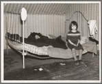 One of Edgar Allen's children sitting on the bed in the house on his farm. There are no sheets, pillowcases, or pillows (other than makeshift) in use. Bedding usually consists of castoff rags and a few old blankets. Near Milford, Iowa