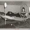 One of Edgar Allen's children sitting on the bed in the house on his farm. There are no sheets, pillowcases, or pillows (other than makeshift) in use. Bedding usually consists of castoff rags and a few old blankets. Near Milford, Iowa