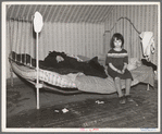 One of Edgar Allen's children sitting on the bed in the house on his farm. There are no sheets, pillowcases, or pillows (other than makeshift) in use. Bedding usually consists of castoff rags and a few old blankets. Near Milford, Iowa