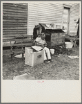 Negro getting a haircut in front of church which houses flood refugees. Sikeston, Missouri