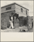 Houses under construction at the Greenhills project. Using the level to lay cinder blocks. Ohio