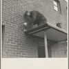 Workmen soldering metal trim on roof. Greenhills, Ohio