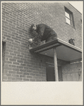 Workmen soldering metal trim on roof. Greenhills, Ohio