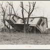 Upturned farmhouse resting against a tree. Result of the flood in Posey County, Indiana.