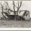 Upturned farmhouse resting against a tree. Result of the flood in Posey County, Indiana