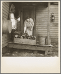 Mrs. Tip Estes, wife of a hired man and mother of nine children, bringing in fuel from the back porch. Near Fowler, Indiana