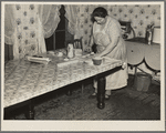 7 a.m. Mrs. Tip Estes, wife of a hired man near Fowler, Indiana, preparing lunches for the five of her nine children who go to school