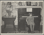 7:45 p.m. After dinner the family sits around in the living room. This is one of the daughters sitting on the stool for the organ (which does not work). Tip Estes family near Fowler, Indiana