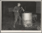 6:40 p.m. Tip Estes, hired man near Fowler, Indiana, filling an automatic hog waterer. He has to carry eighty gallons of water fifty yards to fill this