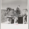 Laying cinder blocks on a house under construction at Greendale, Wisconsin