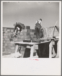 Laying cinder blocks on a house under construction at Greendale, Wisconsin