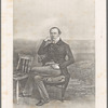 Portrait of a man sitting next to a second chair