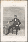 Portrait of a man, hand on second chair in front of studio backdrop