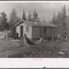 John Nygren sitting in front of his shack near Iron River, Michigan