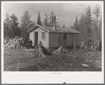 John Nygren sitting in front of his shack near Iron River, Michigan