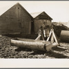 Farmyard of Matt Henry near Tipler, Wisconsin. A primitive water tank hollowed from a tree and a windlass still in operation. Farmers in this region have to make many of their own devices because of lack of funds to purchase manufactured equipment