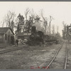 The log train passes through the lumber camp en route to Rhinelander, Wisconsin, where the sawmill of the lumbercamp is located. Forest County, Wisconsin