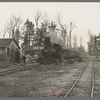 The log train passes through the lumber camp en route to Rhinelander, Wisconsin, where the sawmill of the lumbercamp is located. Forest County, Wisconsin