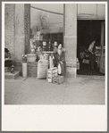 Woman sitting in front of a grocery store. Shawneetown, Illinois