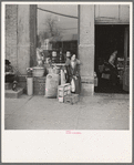 Woman sitting in front of a grocery store. Shawneetown, Illinois