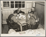 Men eating in the transient camp at Hagerman Lake, Michigan. This is a former lumber camp