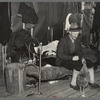 Lon Allen, farmer of the cut-over area near Iron River, Michigan, feeding a chicken in his bedroom. Last winter a cow was brought into the house to keep it from freezing