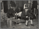 Lon Allen, farmer of the cut-over area near Iron River, Michigan, feeding a chicken in his bedroom. Last winter a cow was brought into the house to keep it from freezing
