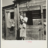 Mother and child in front of woodshed. Gibbs City, Michigan