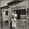 Mother and child in front of woodshed. Gibbs City, Michigan