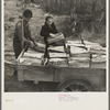 Son and daughter of Lon Allen's loading firewood on the trailer for delivery to the customer. Near Iron River, Michigan