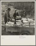 Son and daughter of Lon Allen's loading firewood on the trailer for delivery to the customer. Near Iron River, Michigan