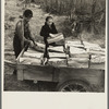 Son and daughter of Lon Allen's loading firewood on the trailer for delivery to the customer. Near Iron River, Michigan