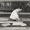 Louis Gushen, chief cutter in the cooperative garment factory at Jersey Homesteads, marks out the pattern of a woman's coat, which will be made in the factory, Hightstown, New Jersey