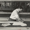 Louis Gushen, chief cutter in the cooperative garment factory at Jersey Homesteads, marks out the pattern of a woman's coat, which will be made in the factory, Hightstown, New Jersey