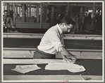 Louis Gushen, chief cutter in the cooperative garment factory at Jersey Homesteads, marks out the pattern of a woman's coat, which will be made in the factory, Hightstown, New Jersey