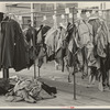 Half-made garments on the racks, awaiting final operations of the machines, in cooperative garment factory, Hightstown, New Jersey