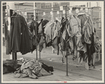 Half-made garments on the racks, awaiting final operations of the machines, in cooperative garment factory, Hightstown, New Jersey
