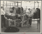 Steam pressing the cloth is one process in manufacturing women's coats at Jersey Homesteads, Hightstown
