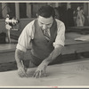 Louis Gushen, chief cutter in the cooperative garment factory at Jersey Homesteads, is cutting the pattern for a woman's coat. Hightstown, New Jersey