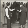 Sam Schultz shows a model coat to a perspective customer at the cooperative garment factory, Jersey Homesteads