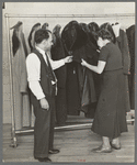 Sam Schultz shows a model coat to a perspective customer at the cooperative garment factory, Jersey Homesteads