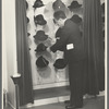 Mr. Leefer, manager of the millinery department, arranges hats in the New York City showroom