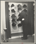 Mr. Leefer, manager of the millinery department, arranges hats in the New York City showroom