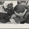 Closeup of man working sewing machine in garment factory, Jersey Homesteads, Hightstown, New Jersey
