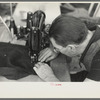 Closeup of man working sewing machine in garment factory, Jersey Homesteads, Hightstown, New Jersey