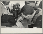Closeup of man working sewing machine in garment factory, Jersey Homesteads, Hightstown, New Jersey