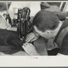 Closeup of man working sewing machine in garment factory, Jersey Homesteads, Hightstown, New Jersey